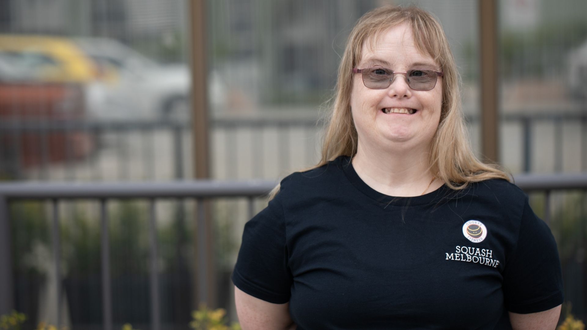 Kelly stands in her uniform outside Squash Melbourne