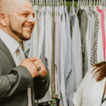 man smiling trying on suit