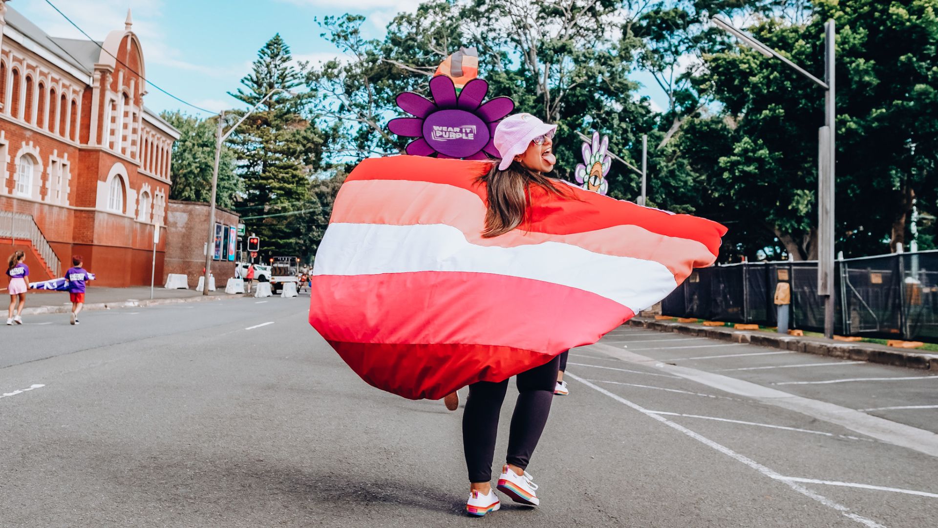 Izzy walking with the lesbian flag down the road