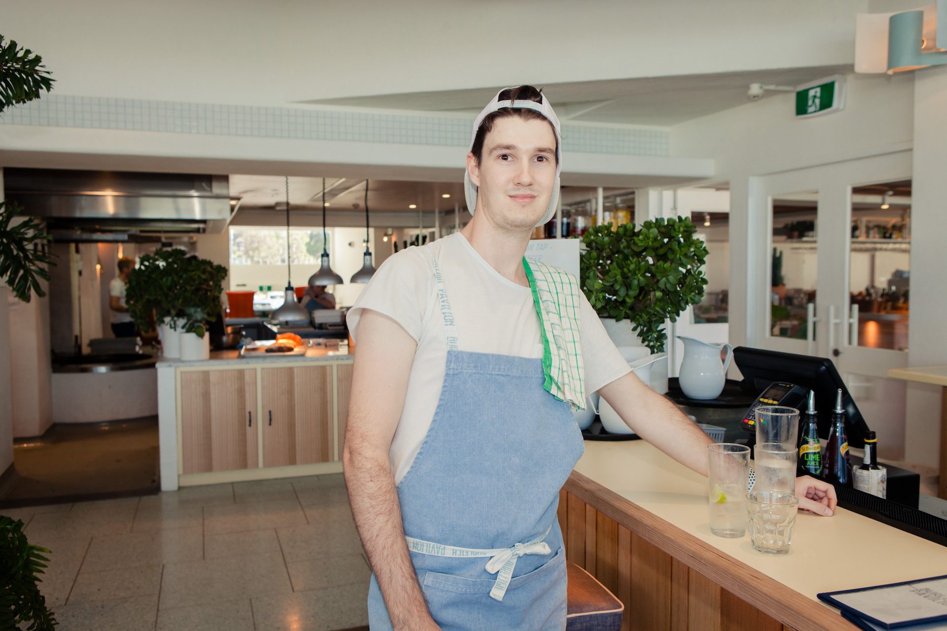 Male waiter bussing glasses.