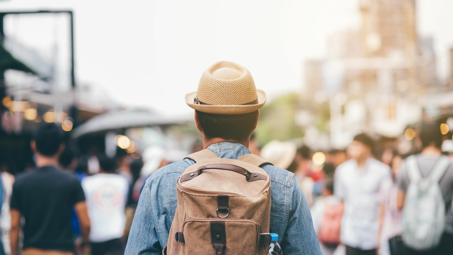 A young man with a backpack, his back facing the camera.