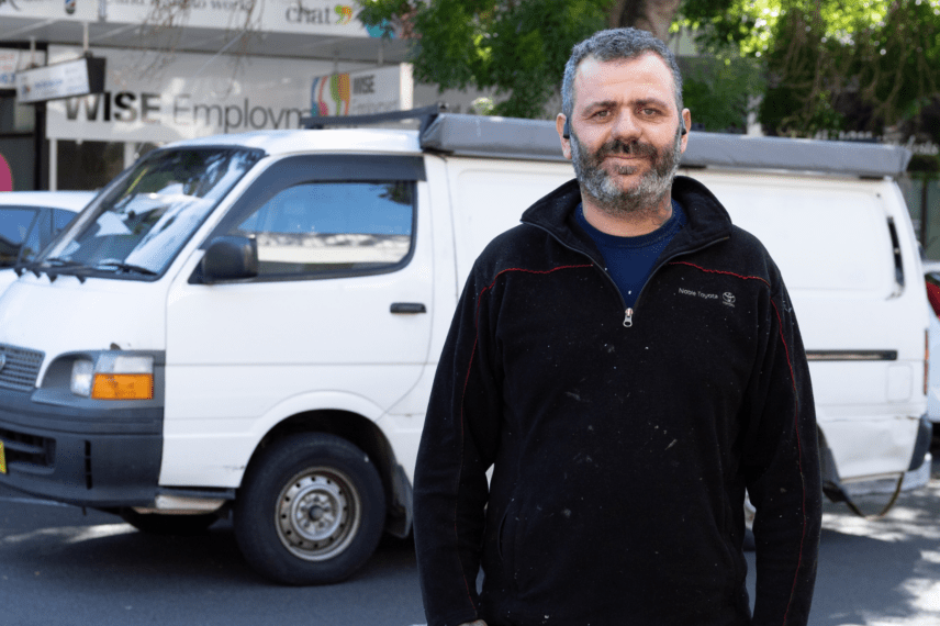 Middle-aged man standing in front of a van at a WISE Employment office.