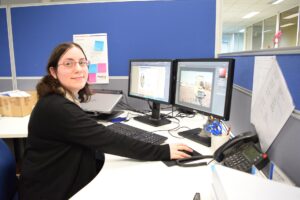 Woman smiling while seated at her office desk.
