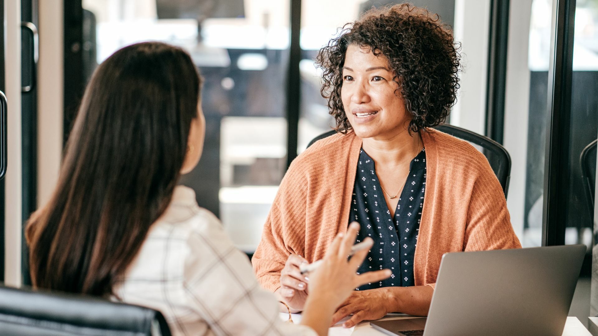 Two women having a discussion at an office.