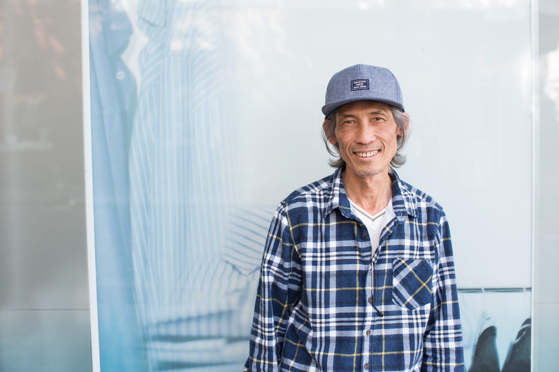 Elderly Asian man working in a drycleaners.