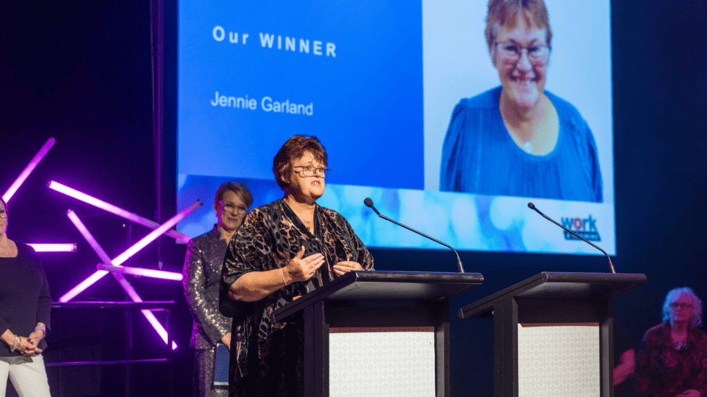 Jennie Garland at podium giving speech