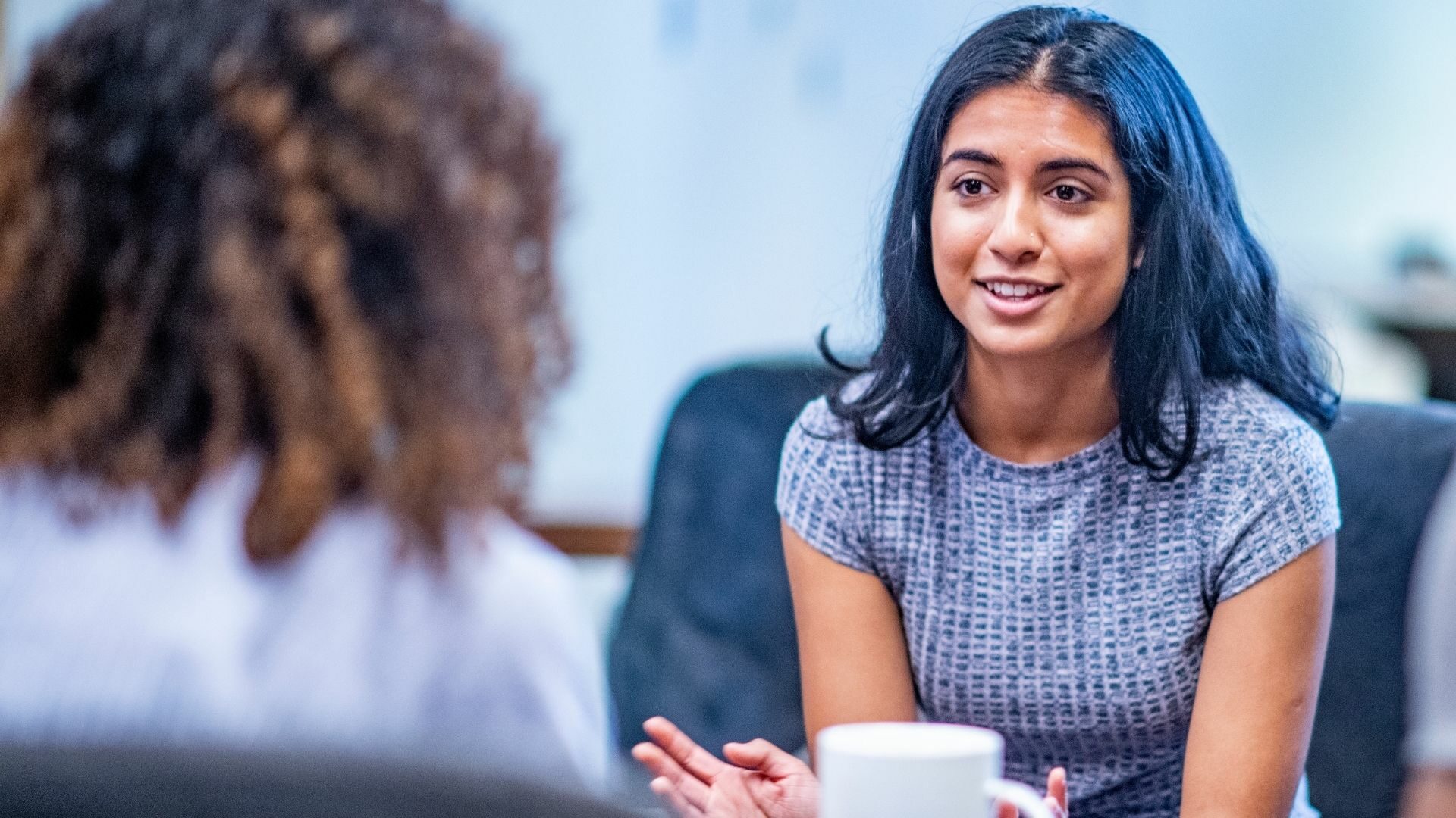 Two women having a conversation over coffee.