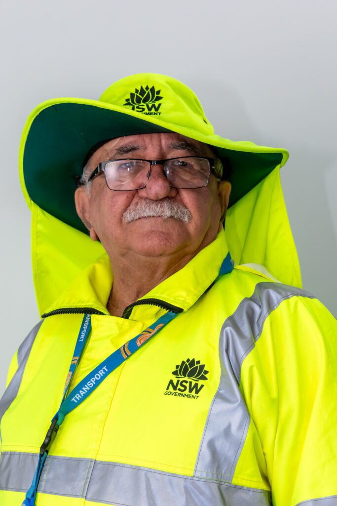 Profile of an elderly man in neon green reflective gear.