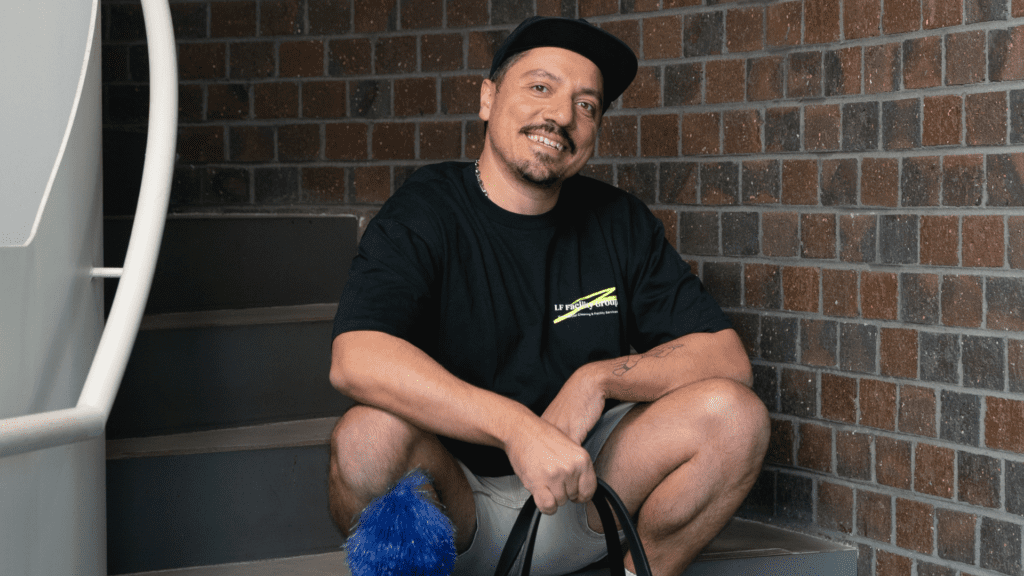 Man wearing a cap and sitting on stairs.